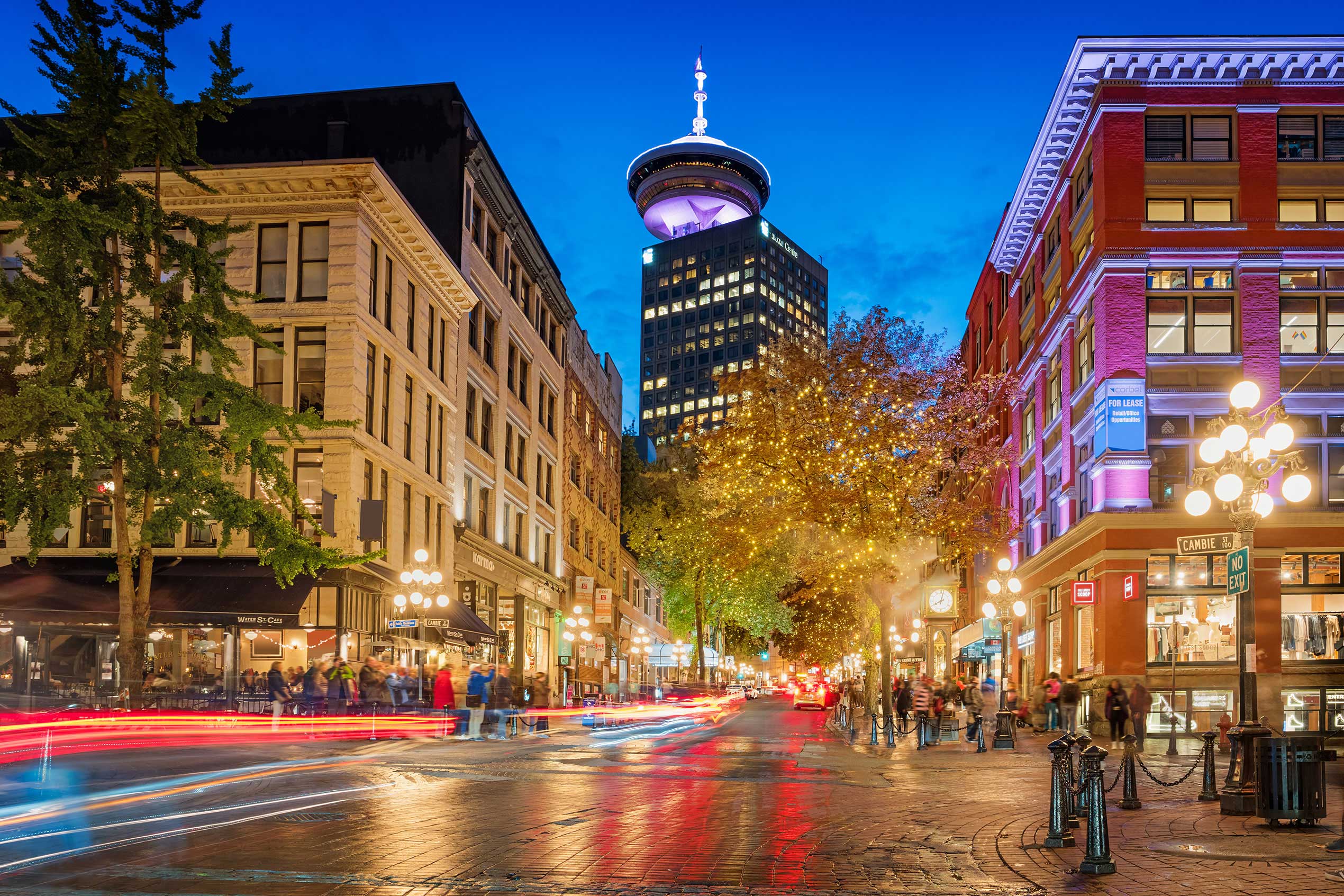 Downtown street with the steam clock and the Vancouver Lookout in the background in Gastown, downtown Vancouver, British Columbia, Canada at twilight.