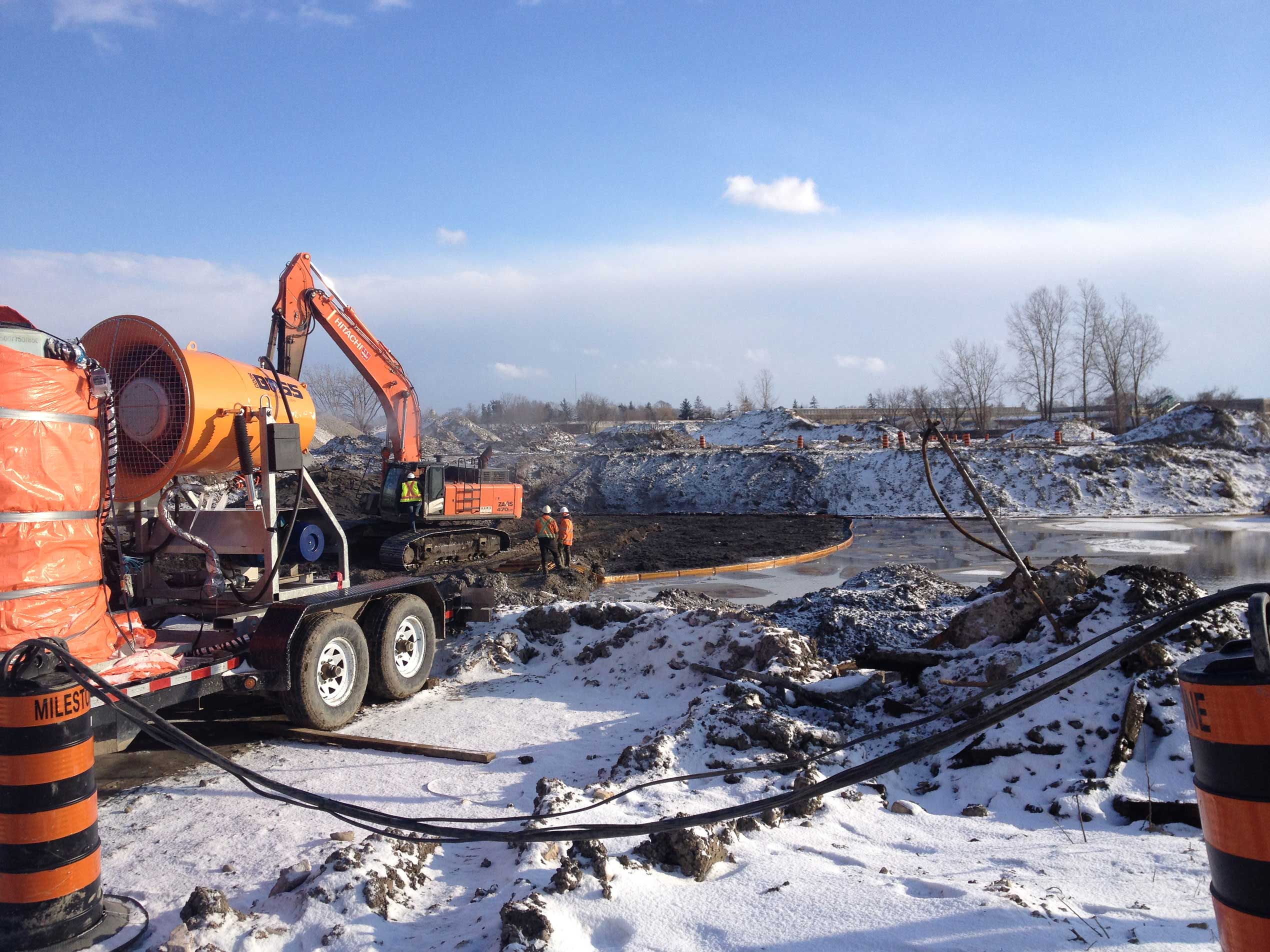 An excavator and truck remediating the soil of the Brantford Brownfield on a sunny winter’s day
