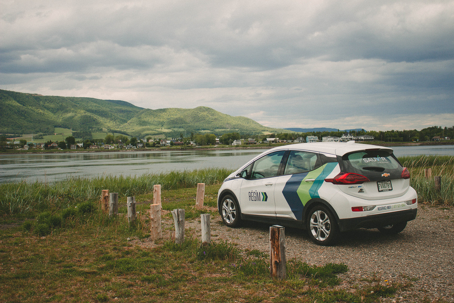 A REGIM branded vehicle parked in front of water and mountains in Quebec Maritimes 