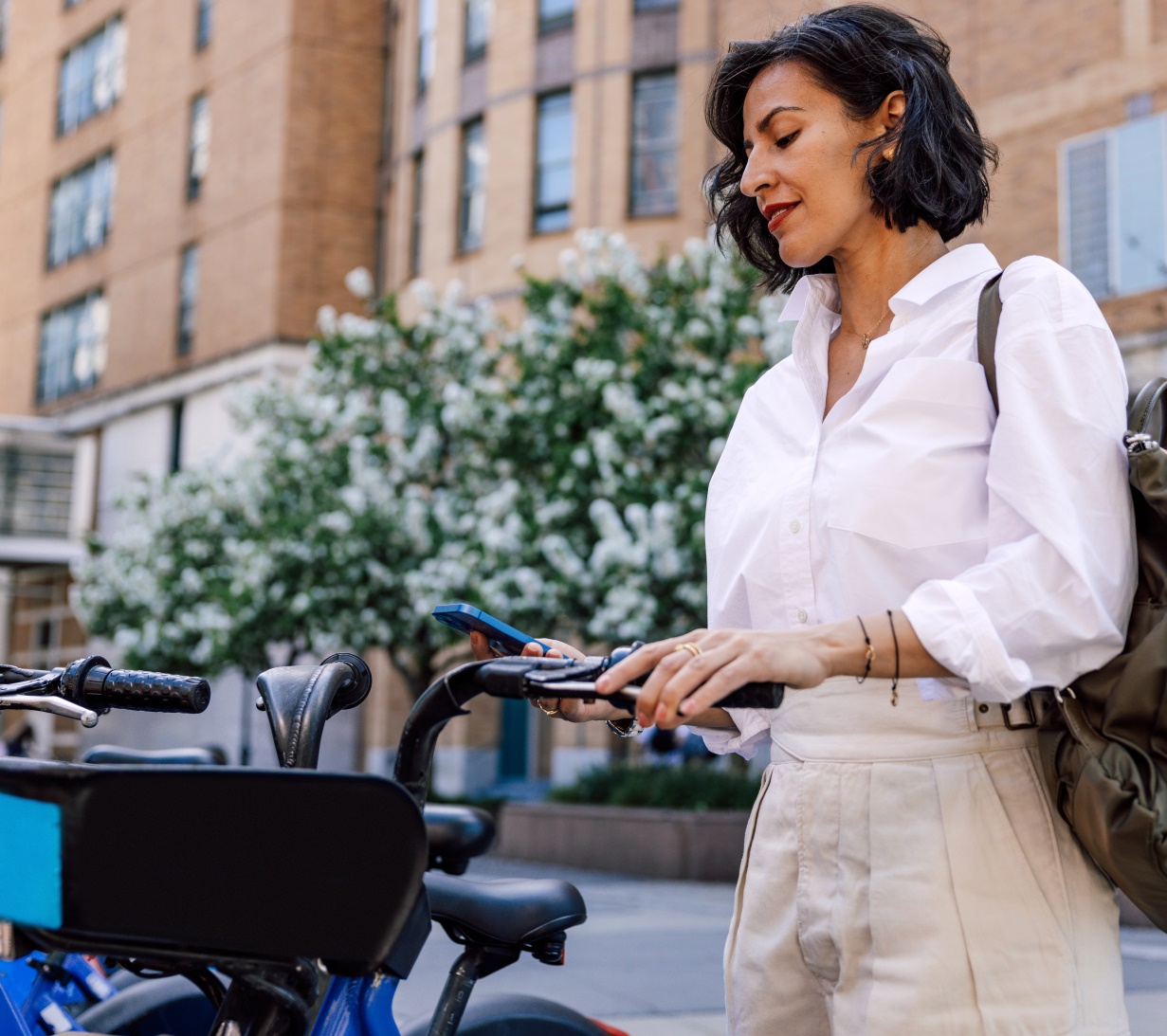 A woman uses her phone to unlock a rent-a-bike