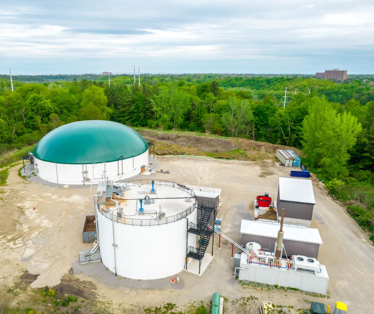 An anerobic digestion facility bordering a green forest in Ontario Canada. 