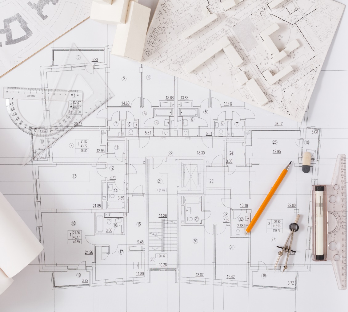 Overhead view of blueprints for a new municipal building with pencils, compasses and protractors scattered on the paper