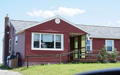 A single-storey home painted dark red in Pine Tree Park Estates.