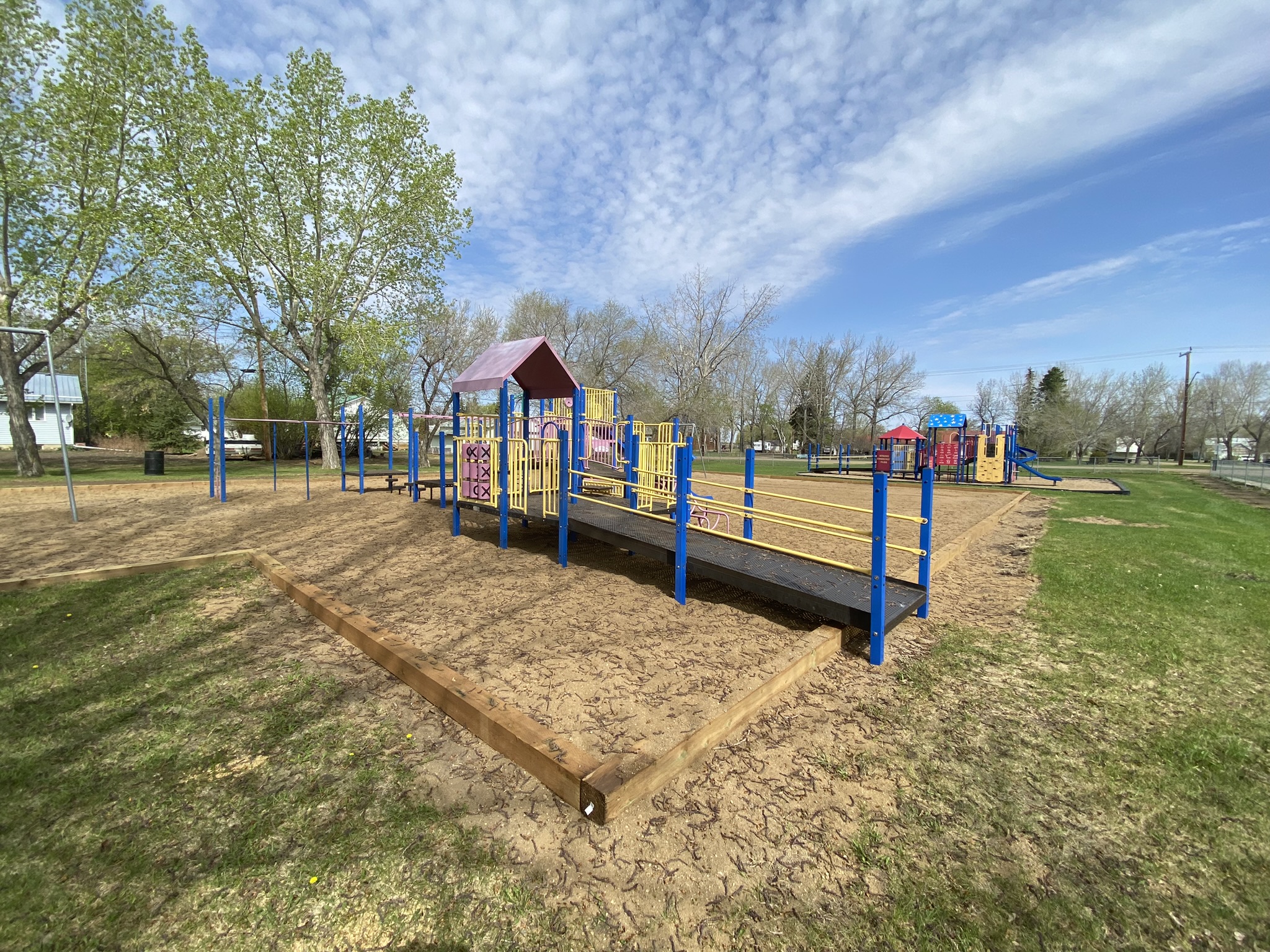 Wide view of a small playground on a sunny day. 