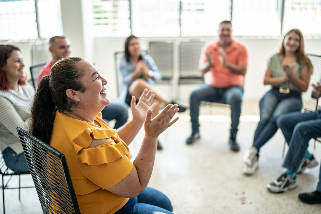 Group of people sitting in a circle smiling and laughing 