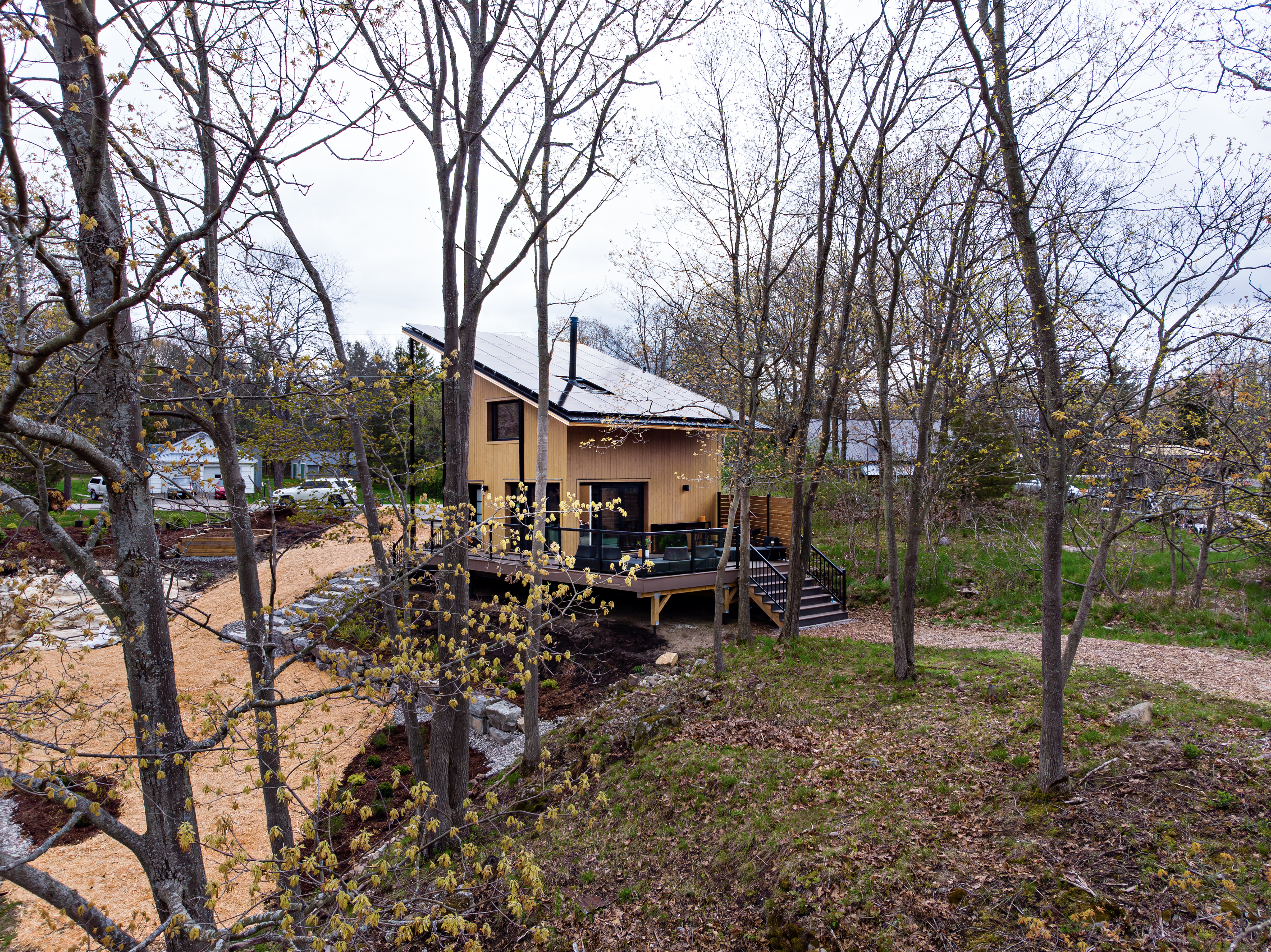 Une maison CABN achevée sur un grand terrain entouré d'arbres