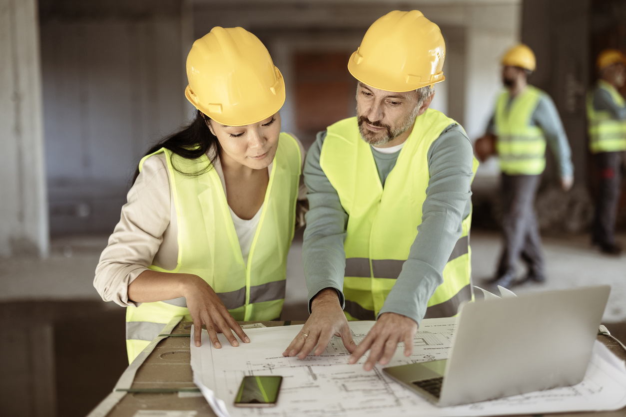 Municipal staff reviewing blueprints for a climate adaptation infrastructure project. 