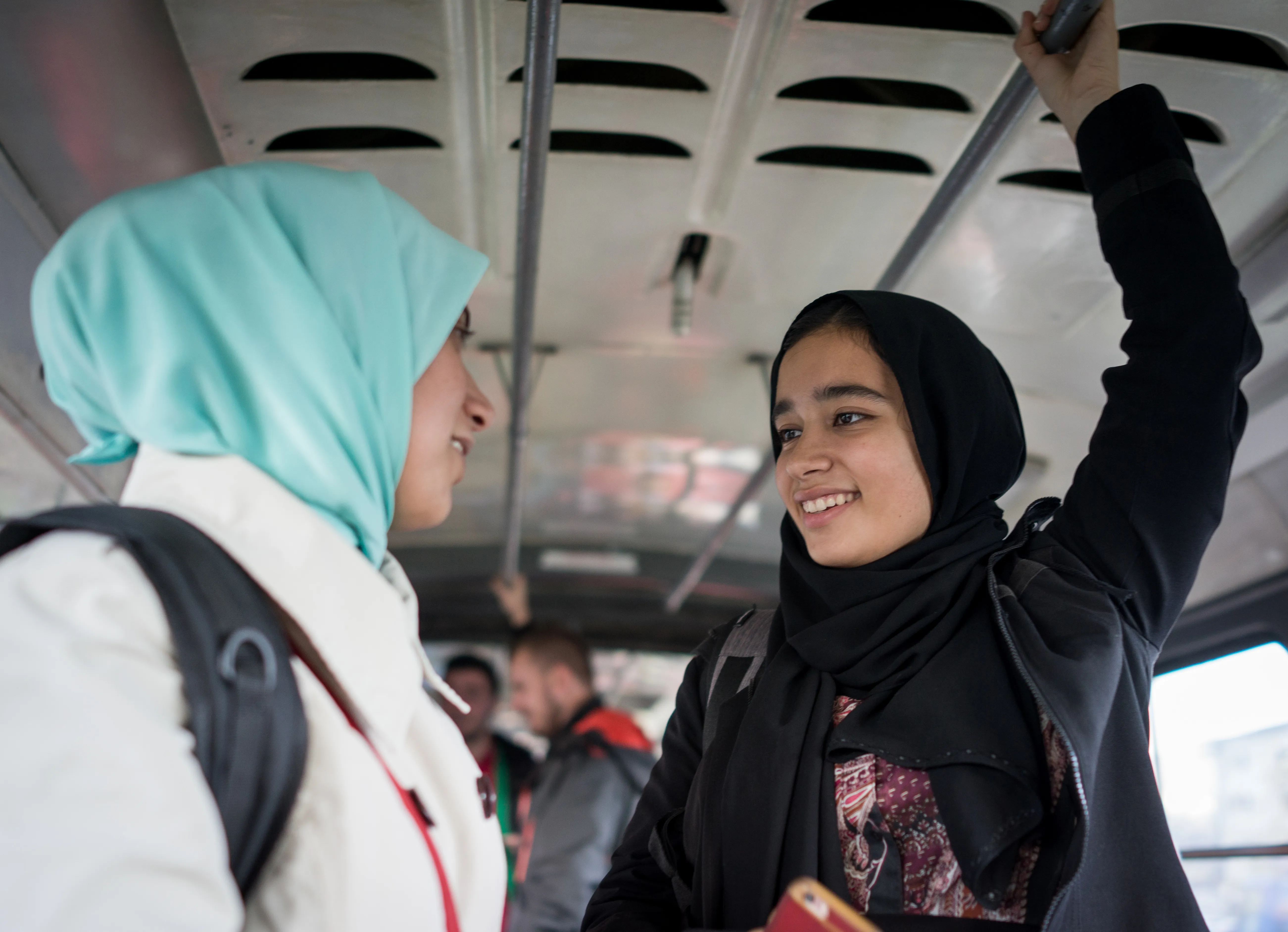 two girls riding on the city bus