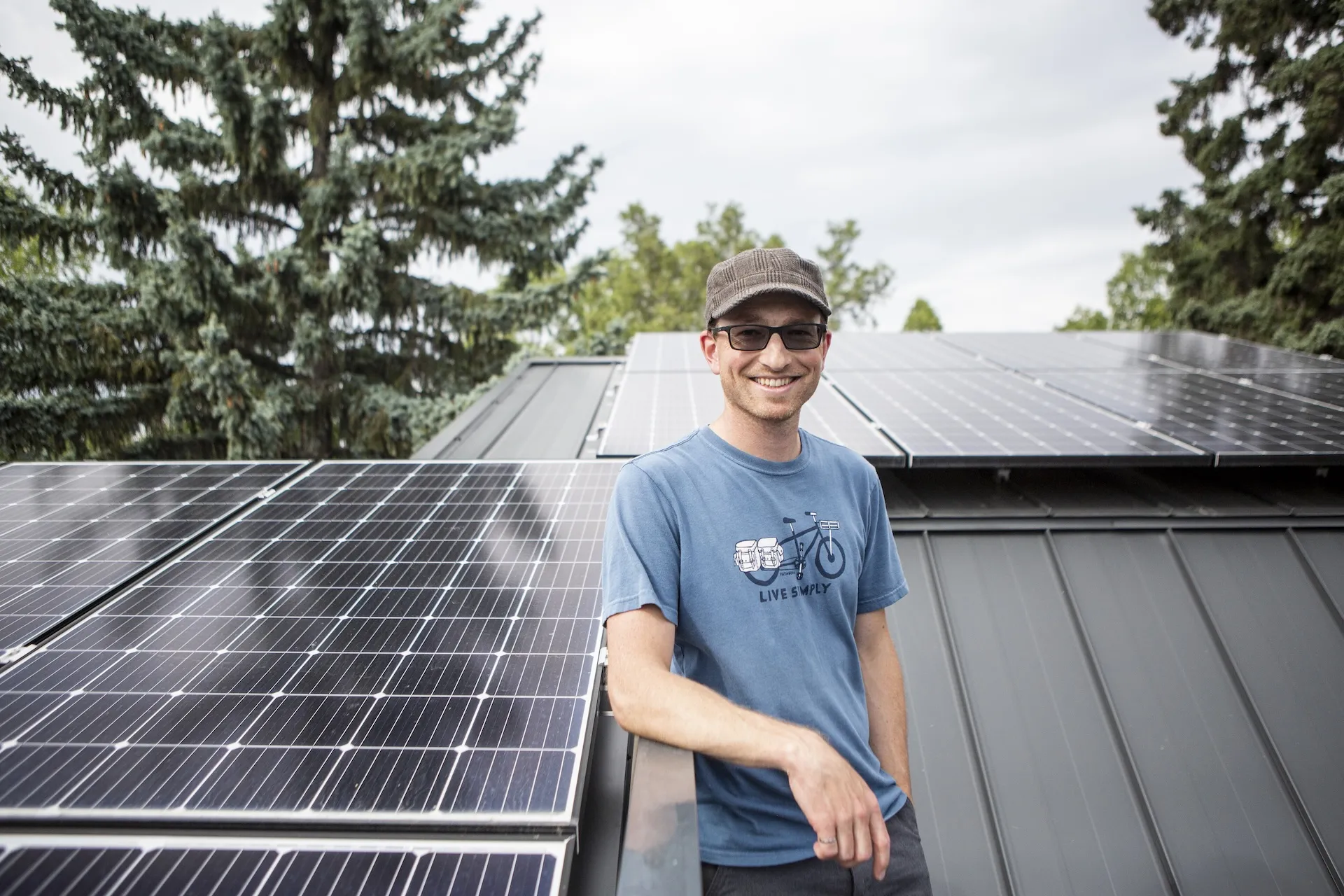 Man Smiling with Solar Panels behind him