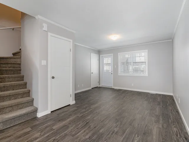 A clean, empty living room and staircase in a unit at the Aspen Heights townhouse complex in Saskatoon 